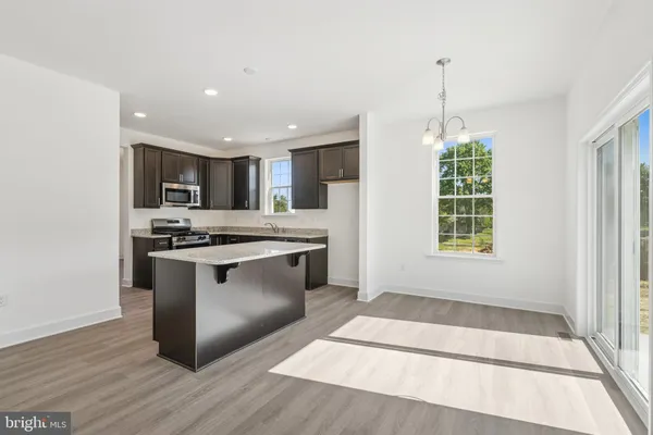 a kitchen with stainless steel appliances granite countertop a stove a sink and a wooden floors