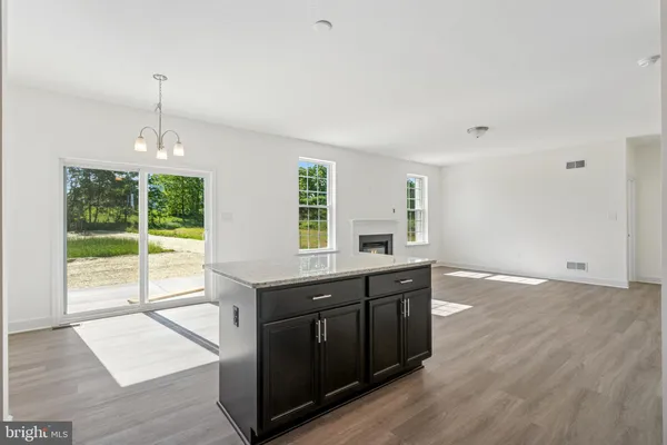a kitchen with stainless steel appliances granite countertop a stove a sink and a wooden floors