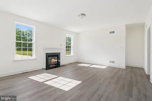 a view of empty room with a fireplace and window