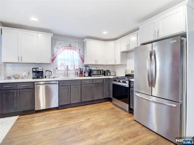 a kitchen with granite countertop a refrigerator stove top oven and sink
