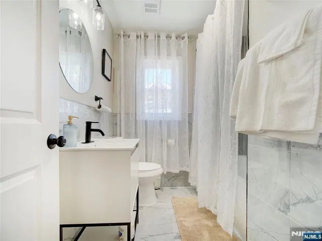 a bathroom with a sink a toilet and a mirror