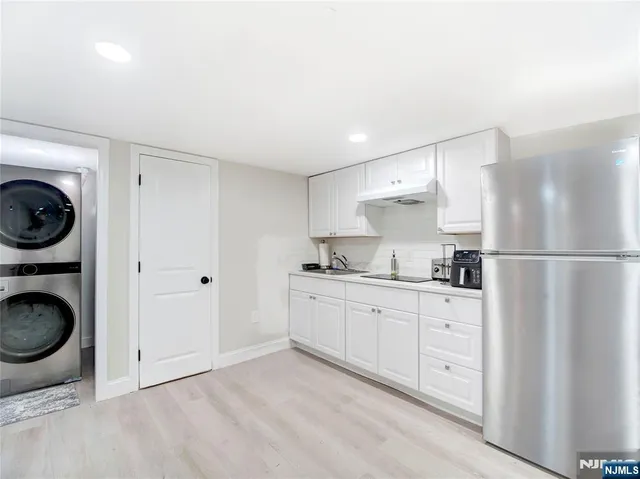 a kitchen with a refrigerator sink and cabinets