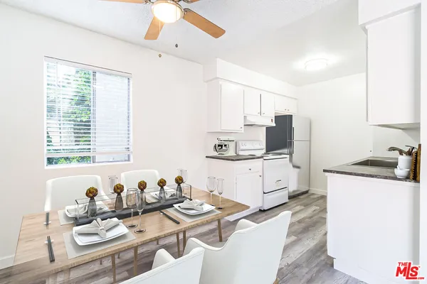 a kitchen with stainless steel appliances kitchen island granite countertop a sink and white cabinets