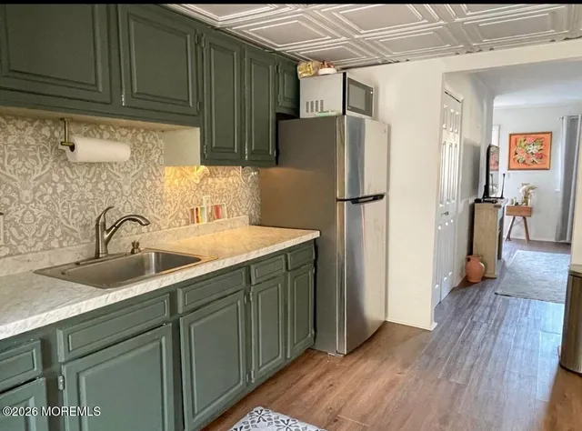 a kitchen with stainless steel appliances granite countertop a refrigerator and a sink