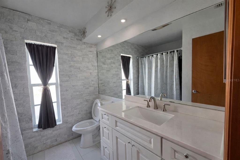 2202 Perry Avenue Spring Hill, FL 34609 - Photo 2 of 11 a bathroom with a granite countertop sink toilet and shower