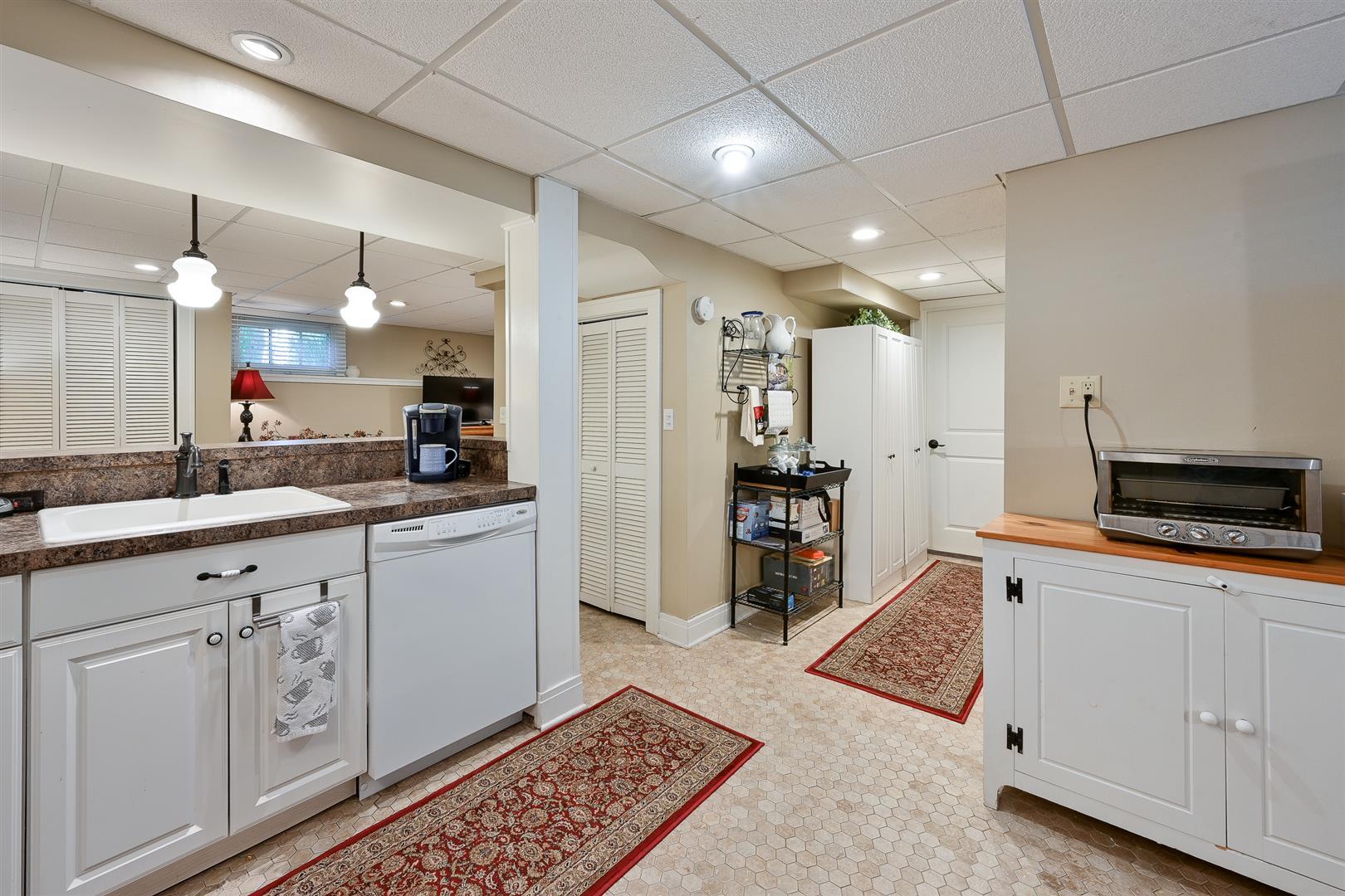 804 Warrenville Road Wheaton, IL 60189 - Photo 22 of 30 a large white kitchen with a lot of counter space and a wooden floor
