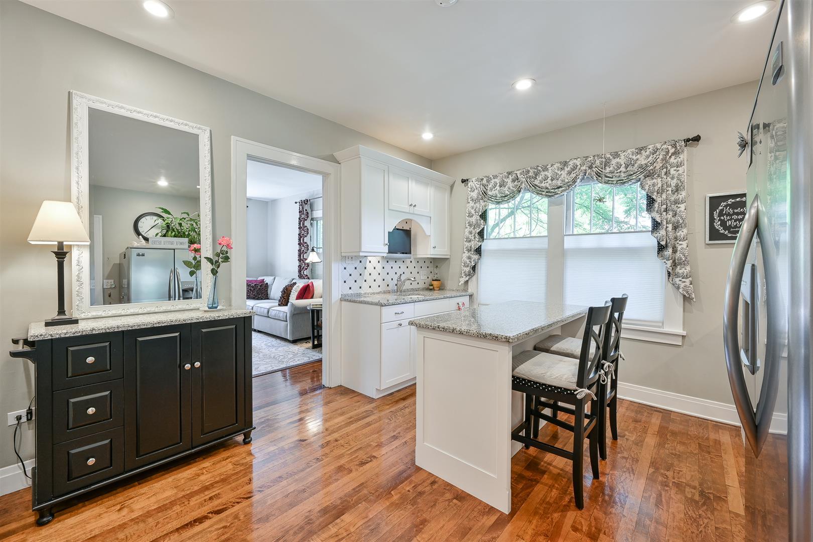 804 Warrenville Road Wheaton, IL 60189 - Photo 9 of 30 a kitchen with stainless steel appliances granite countertop a refrigerator a sink dishwasher and a dining table with wooden floor