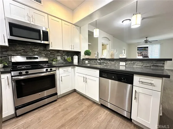 a kitchen with stainless steel appliances granite countertop a stove microwave and sink