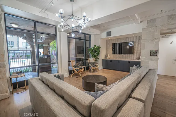 a living room with furniture a chandelier and a flat screen tv
