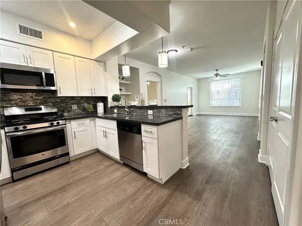 a kitchen with stainless steel appliances granite countertop a stove a sink and a refrigerator