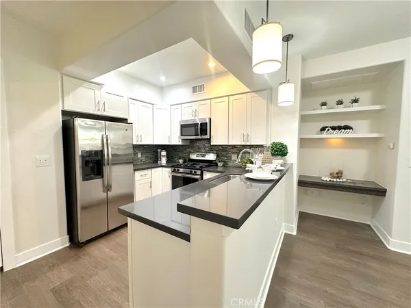 a kitchen with stainless steel appliances granite countertop a sink a stove and refrigerator