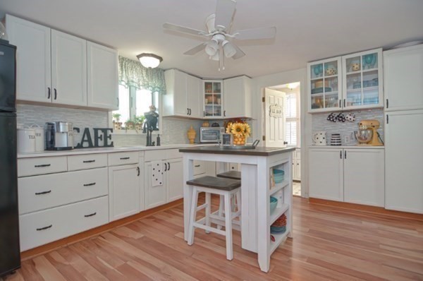 a kitchen with cabinets wooden floor and stainless steel appliances