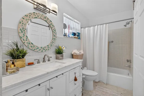 a bathroom with a granite countertop sink a toilet and a mirror