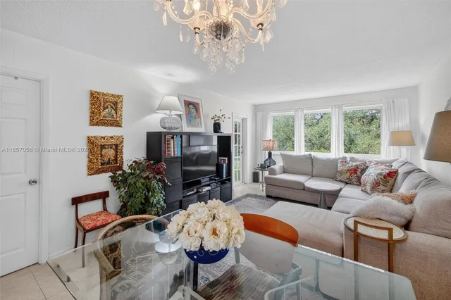 a living room with furniture a chandelier and a flat screen tv
