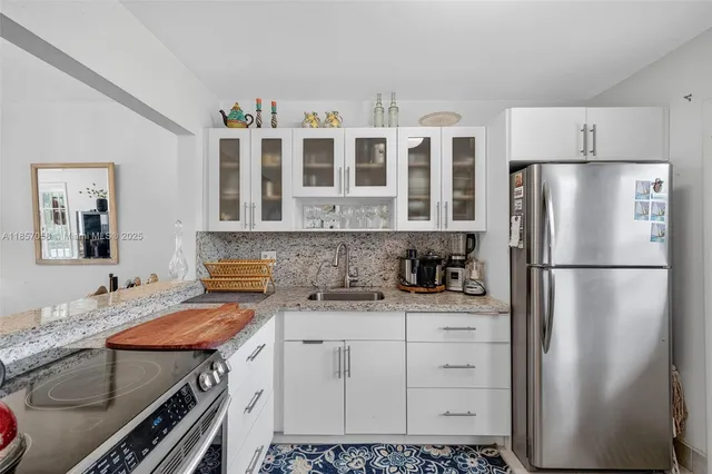 a kitchen with stainless steel appliances a refrigerator a sink and cabinets