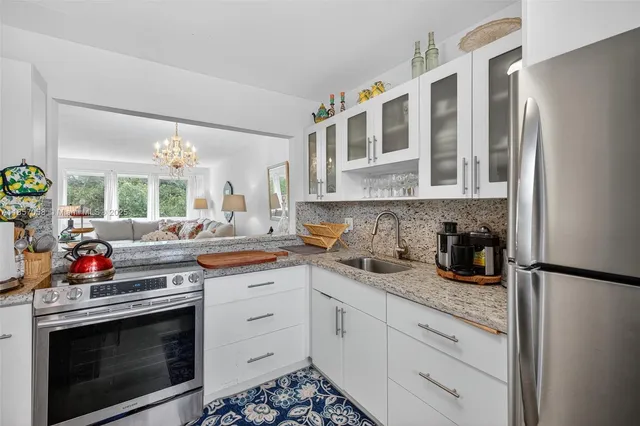 a kitchen with stainless steel appliances granite countertop a stove a sink and a refrigerator