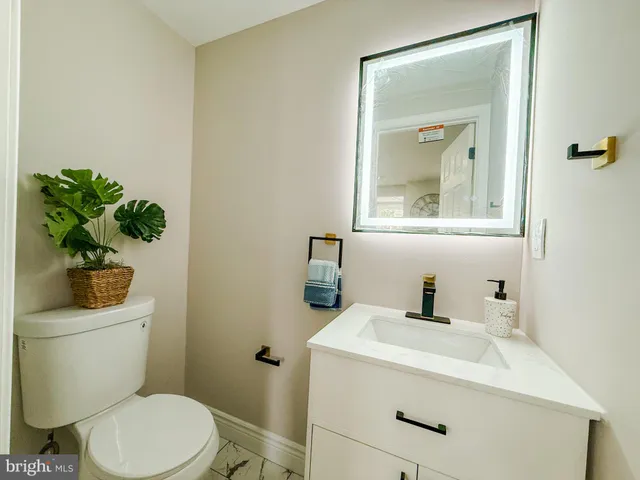 a bathroom with a toilet a sink and mirror