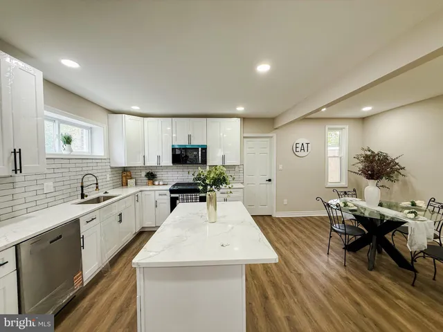 a kitchen with a sink white cabinets and counter space