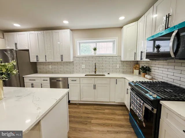 a kitchen with stainless steel appliances a sink stove and cabinets