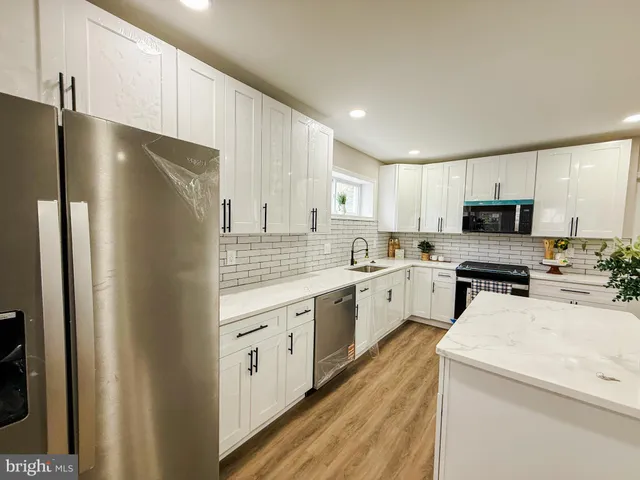 a kitchen with white cabinets and stainless steel appliances