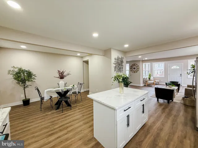 a large kitchen with kitchen island a stove a sink a dining table and chairs