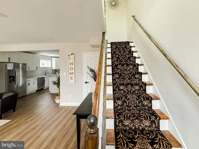 a view of a hallway with wooden floor and staircase