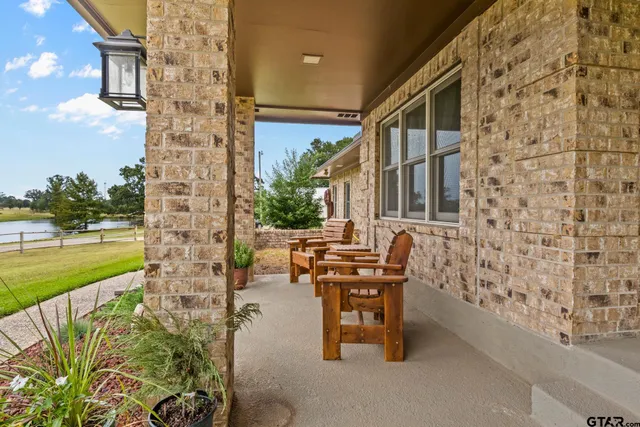 a balcony with table and chairs with potted plants