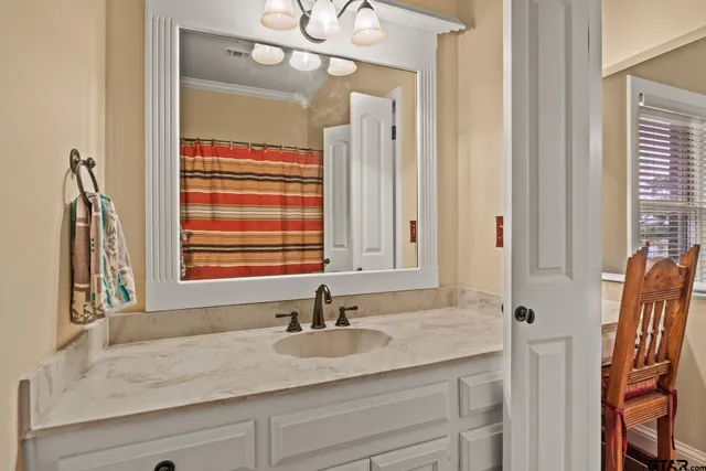a bathroom with a granite countertop sink and a mirror