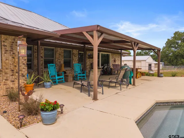 a view of the patio with table and chairs potted plants and floor to ceiling window
