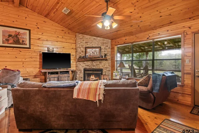 a living room with furniture a flat screen tv and a fireplace