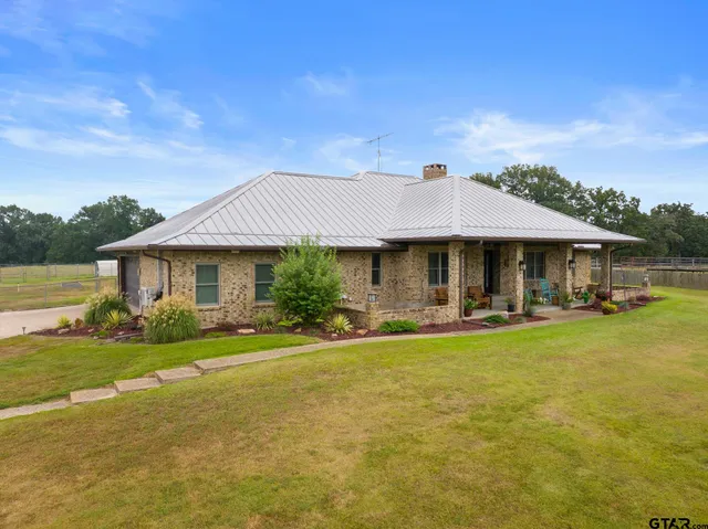 a front view of a house with swimming pool having outdoor seating