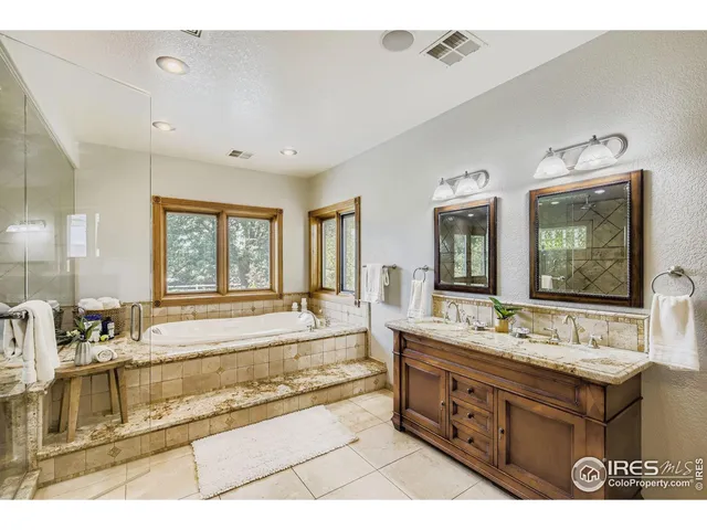 a bathroom with a tub sink and mirror