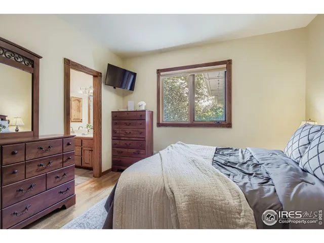 a bedroom with a bed and furniture with mirror