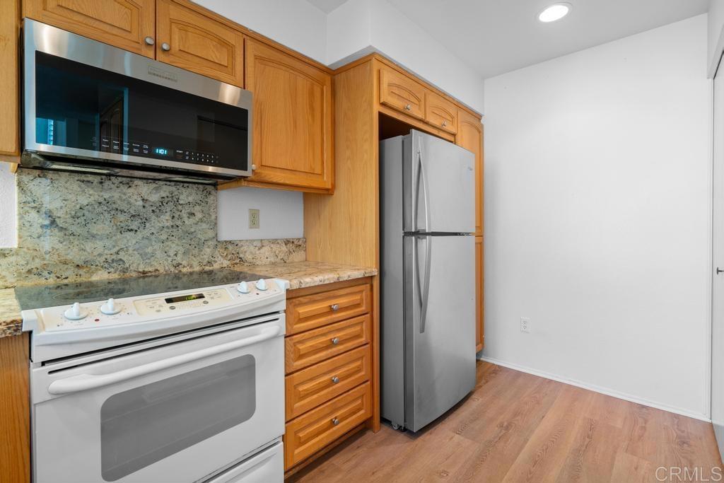 1446 Finch Street El Cajon, CA 92020 - Photo 14 of 35 a kitchen with granite countertop cabinets stainless steel appliances and wooden floor