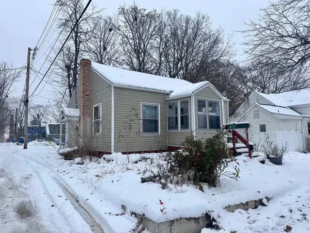 a view of a house with a yard covered in snow
