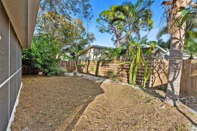 a view of a house with a large window and wooden fence