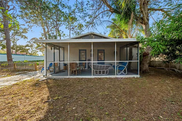 a view of a house with a backyard and a tree