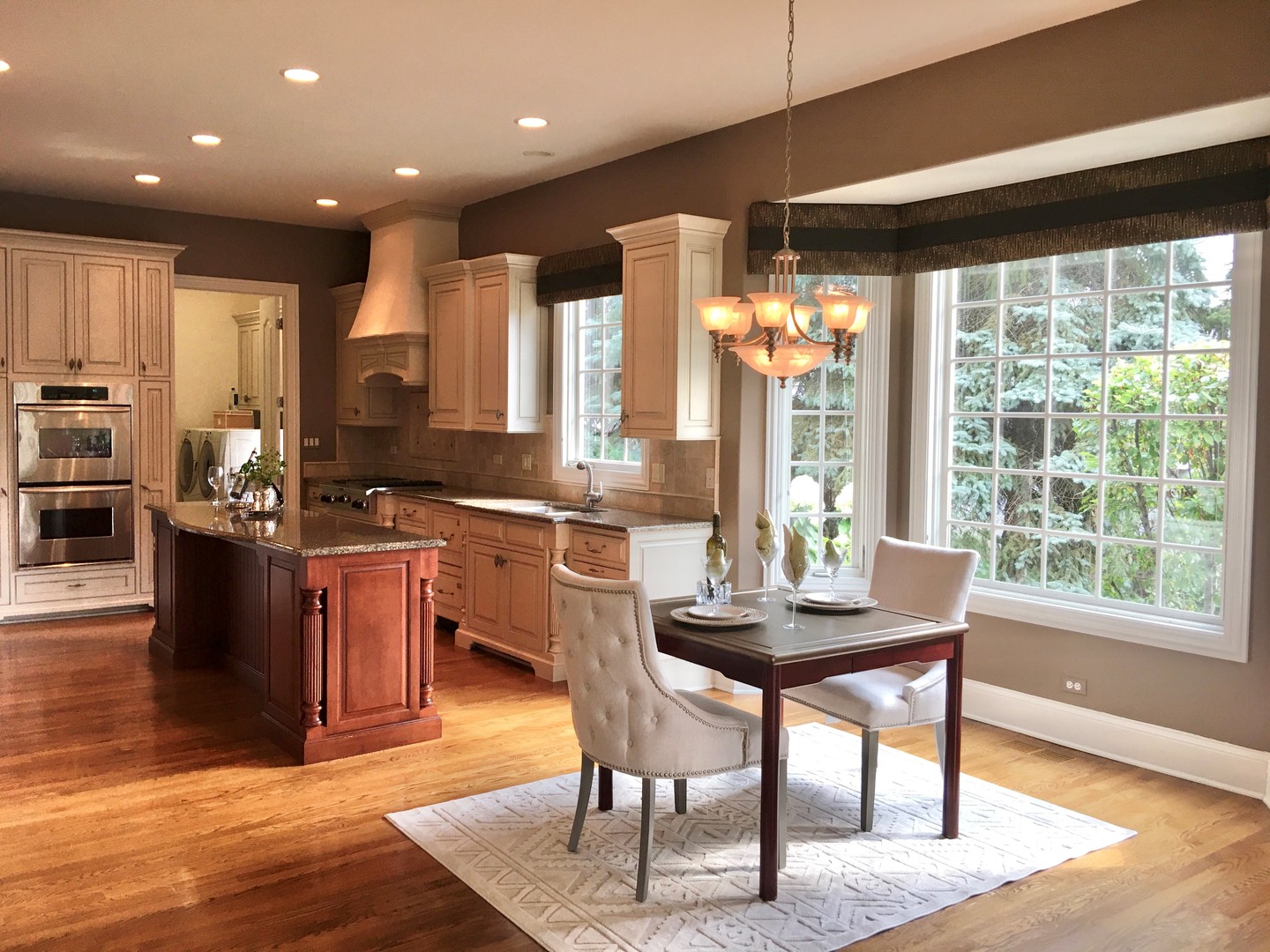 59 Forest Gate Circle Oak Brook, IL 60523 - Photo 12 of 30 a kitchen with stainless steel appliances kitchen island granite countertop a stove a refrigerator a sink a dining table and chairs with wooden floor