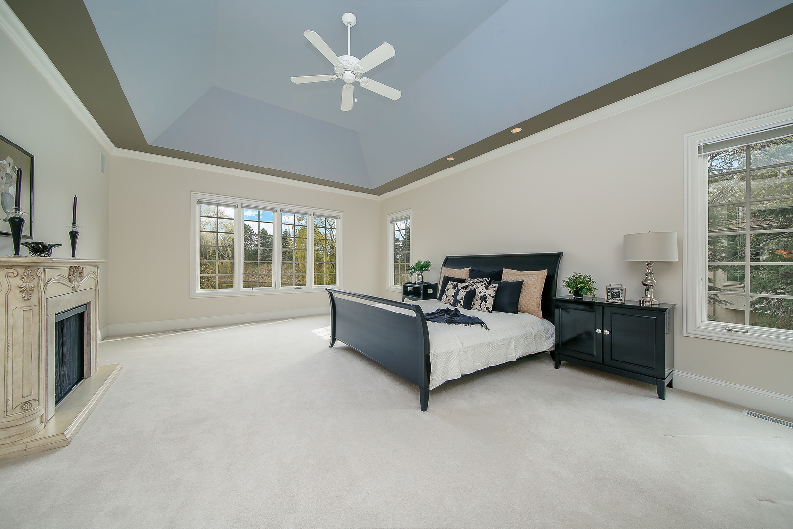59 Forest Gate Circle Oak Brook, IL 60523 - Photo 17 of 30 a spacious bedroom with a bed chandelier and fireplace