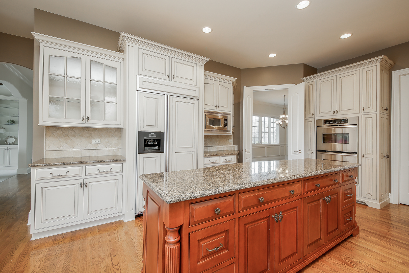 59 Forest Gate Circle Oak Brook, IL 60523 - Photo 9 of 30 a kitchen with stainless steel appliances granite countertop a refrigerator a stove and a sink with wooden floor