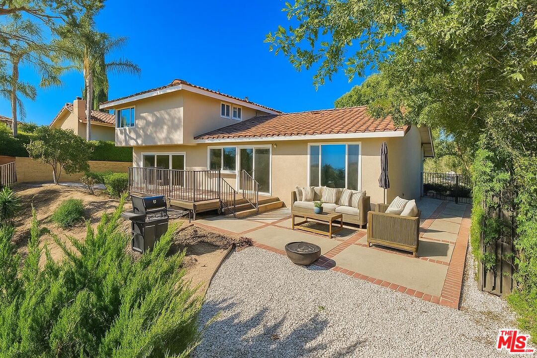 1096 Stoneshead Court Westlake Village, CA 91361 - Photo 12 of 38 a view of a patio with couches table and chairs under an umbrella