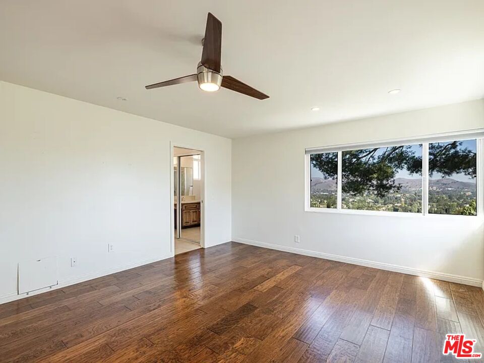 1096 Stoneshead Court Westlake Village, CA 91361 - Photo 21 of 38 an empty room with wooden floor fan and windows