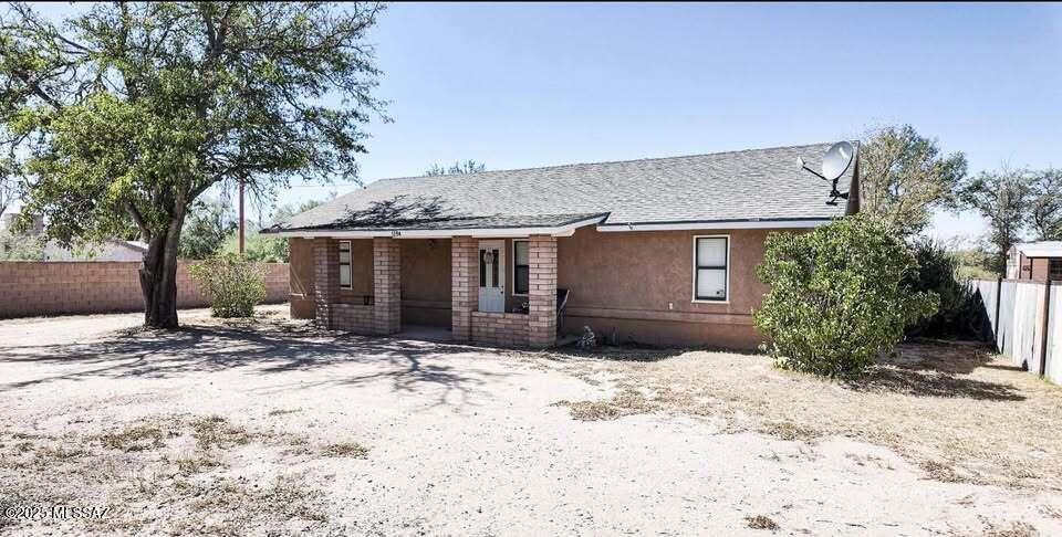1094 North Pomerene Road Benson, AZ 85602 - Photo 15 of 48 a front view of a house with a yard and a garage
