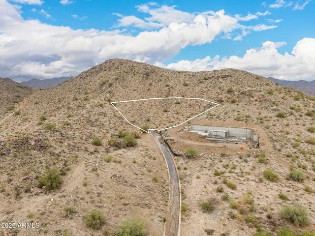 a view of a dry yard with mountains in the background