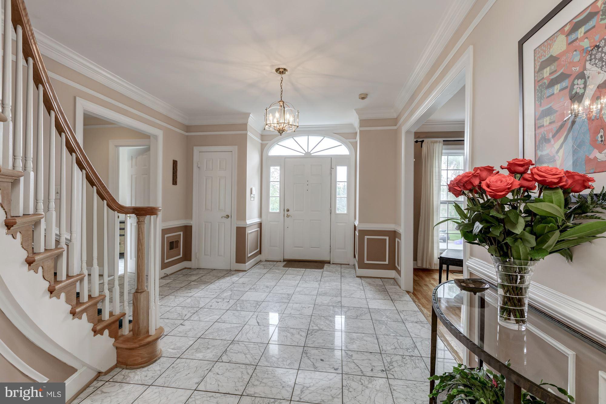 8745 Hickory Bend Trail Potomac, MD 20854 - Photo 2 of 30 a view of an entryway with a flower pot and a bookshelf