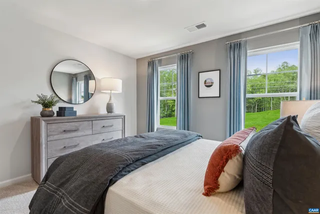 a bedroom with a bed mirror and a window