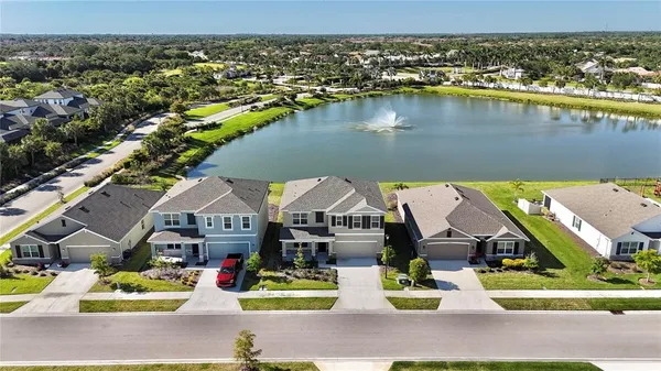 an aerial view of a house with a garden and lake view