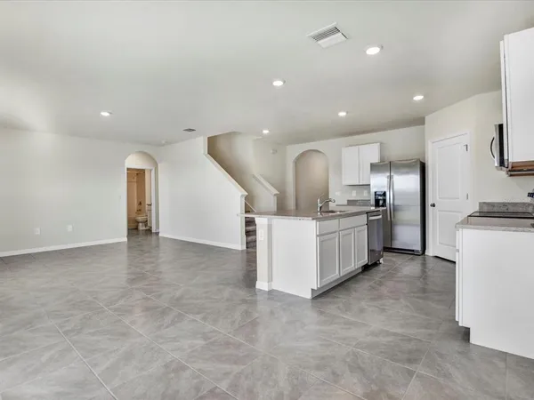 a view of a kitchen with refrigerator and white cabinets