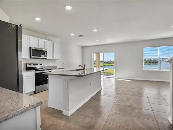 a large kitchen with a large counter top stainless steel appliances and cabinets