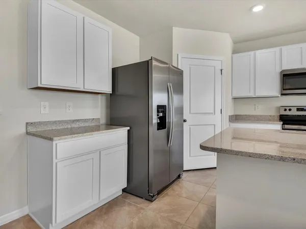 a kitchen with stainless steel appliances granite countertop a refrigerator a stove and a sink